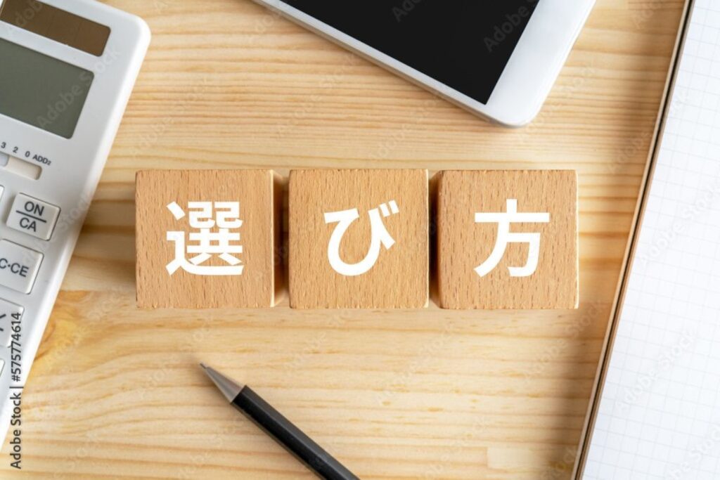 選び方と書かれたブロック、電卓、スマホ、ノート